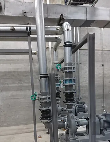 工場の配管システムとポンプが設置されたコンクリート壁の前の産業用設備。