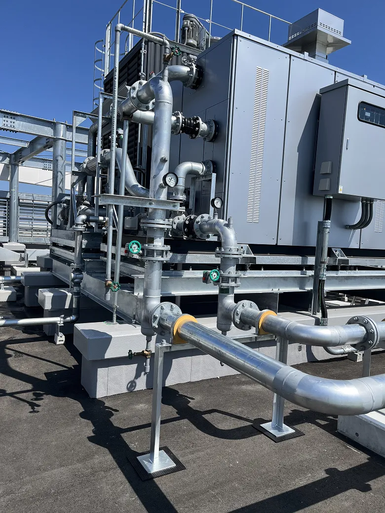 屋上に設置された複雑な金属配管と制御装置がついた産業用空調設備。